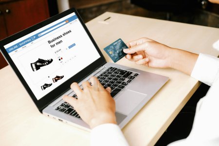 Téléchargez les photos : Jeune homme utiliser la carte de crédit pour faire des achats en ligne sur l'application d'ordinateur portable ou site Web. E-commerce et concept d'achat en ligne. uds - en image libre de droit