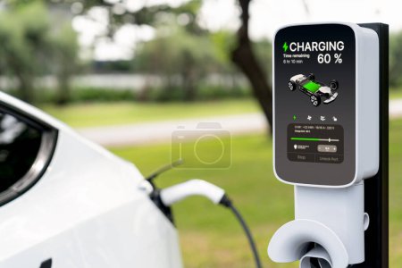 Photo for EV electric vehicle recharging battery from EV charging station in outdoor green city park scenic. Natural protection with eco friendly EV car travel. Exalt - Royalty Free Image