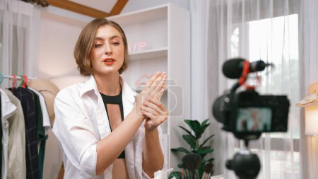 Photo for Woman influencer shoot live streaming vlog video review clothes prim social media or blog. Happy young girl with apparel studio lighting for marketing recording session broadcasting online. - Royalty Free Image