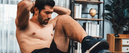 Photo for Athletic and sporty man doing crunch on fitness mat during home body workout exercise session for fit physique healthy sport lifestyle at home. Panorama banner gaiety home exercise workout training - Royalty Free Image