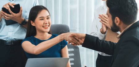 Photo for Diverse coworkers celebrate success with handshake and teamwork in corporate workplace. Multicultural team of happy professionals united in solidarity by handshaking in office. Concord - Royalty Free Image