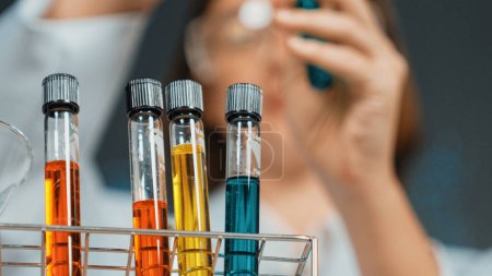 Photo for Scientist bring colored solution or chemical liquid doing experiment at laboratory. Teacher bring biological sample to look under microscope in STEM science class. Blurring background. Erudition. - Royalty Free Image