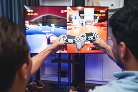 Photo for Close up photo of holding joystick crashing or cheerful friends on car racing competition of video game on blurred screen. Concept of lifestyles gamer on weekend with friend in living room. Sellable. - Royalty Free Image
