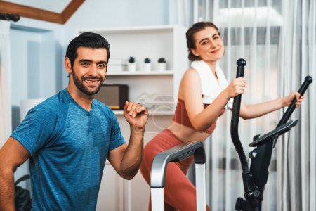 Photo for Athletic and sporty young couple or fitness buddy running on running machine together, home body workout exercise session as healthy sport lifestyle at home. Gaiety home exercise workout training. - Royalty Free Image