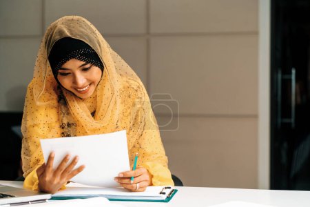 Foto de Exitosa empresaria musulmana de Oriente Medio que trabaja en el cargo. Concepto de éxito empresarial internacional. BARROS - Imagen libre de derechos