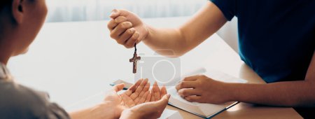 Photo for Close-up women prayer deliver holy bible book and holy cross to young believer. Spreading religion symbol. Concept of hope, religion, christianity and god blessing. Warm background. Burgeoning. - Royalty Free Image