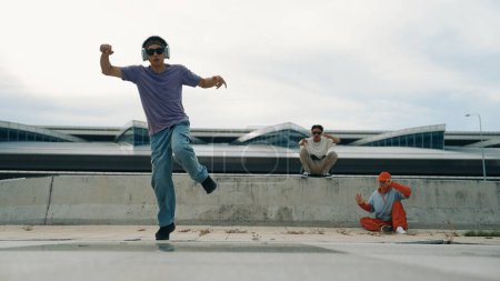 Photo for Group of skilled break dancer perform street dance with friend looking and cheering at him. Handsome hipster practice b boy dance at street while listening to music. Outdoor sport 2024. Sprightly. - Royalty Free Image