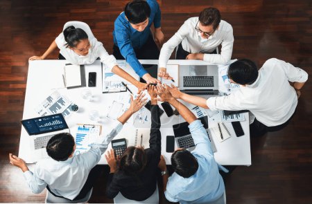 Foto de Top view diverso trabajador de oficina se unen de la mano en la sala de oficina simbolizan la sinergia empresarial y el fuerte trabajo en equipo productivo en el lugar de trabajo. Cooperación y unidad entre empleados de negocios. Prudente - Imagen libre de derechos