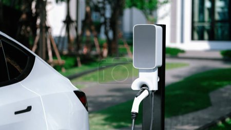 Photo for EV electric car charging in green sustainable city outdoor garden in summer. Urban sustainability lifestyle by green clean rechargeable energy of electric BEV vehicle innards - Royalty Free Image