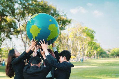 Téléchargez les photos : Concept de journée de la Terre avec grand globe terrestre tenu par un groupe de gens d'affaires asiatiques équipe promouvant la sensibilisation à l'environnement pour résoudre le réchauffement climatique avec la durabilité environnementale et le principe ESG. Pneumatique - en image libre de droit