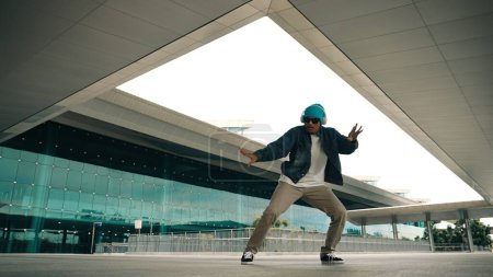 Photo for Motion shot of happy hipster practice b boy dance with stylish cloth at building. Dancer enjoy show footstep performance. Modern lifestyle, break dancing. Slow motion. Outdoor sport 2024. Sprightly. - Royalty Free Image