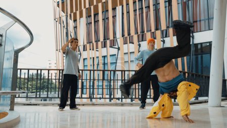 Photo for Hip hop team dance break dance while multicultural friend surrounded and clapping hands to cheer or encourage his friend to dance. Active and energetic street dance. Outdoor sport 2024. Endeavor. - Royalty Free Image