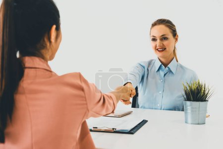 Foto de Dos mujeres de negocios jóvenes en reunión en la mesa de la oficina para la aplicación de empleo y el acuerdo de negocios. Concepto de reclutamiento y recursos humanos. BARROS - Imagen libre de derechos