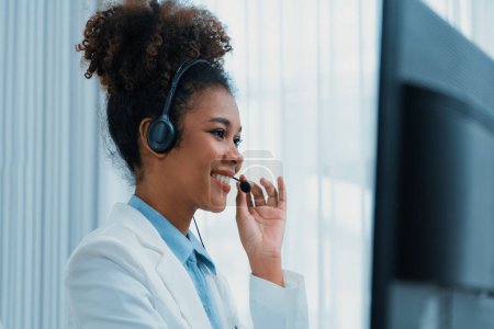 Photo for African American businesswoman wearing headset working in office to support remote crucial customer or colleague. Call center, telemarketing, customer support agent provide service on video call. - Royalty Free Image