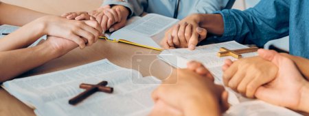 Photo for Cropped image of diversity people hand praying together at wooden church on bible book while hold hand together with believe. Concept of hope, religion, faith, god blessing concept. Burgeoning. - Royalty Free Image