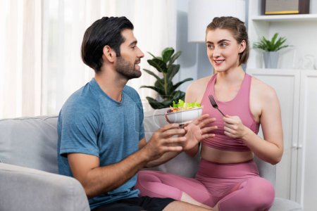 Photo for Healthy sporty and vegetarian couple in sportswear with a bowl of fruit and vegetable. Healthy cuisine nutrition and vegan lifestyle for fitness body physique at gaiety home concept. - Royalty Free Image
