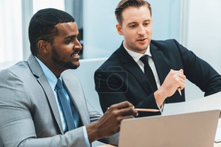 Photo for African male leader explain strategy while show solution to professional project manager by pointing at document, using laptop. Skilled business team brainstorming idea. Business meeting. Ornamented. - Royalty Free Image