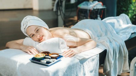 Photo for Relaxing beautiful young woman lies on spa bed near ingredients of homemade facial mask while looking at camera surrounded by beauty electrical equipment. Healthy and beauty concept. Tranquility. - Royalty Free Image