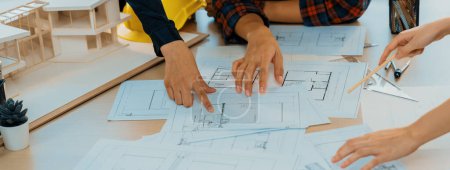 Photo for Experienced architects and engineers collaborate on house design and construction. Skilled interior design team discuss about house structure while project manager pointing at blueprint. Burgeoning. - Royalty Free Image
