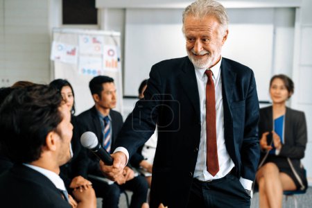 Photo for Senior leader speaker speaks to public people audience in training workshop or conference. Mature lecturer is CEO executive manager leading symposium event. International business seminar concept. uds - Royalty Free Image