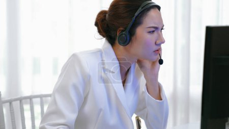 Foto de Mujer de negocios que usa auriculares que trabajan en la oficina para apoyar a un cliente remoto o colega. Agente de atención al cliente frustrado y cansado centro de llamadas que enfrenta el problema de proporcionar un servicio de vivacidad - Imagen libre de derechos