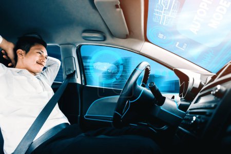 Téléchargez les photos : Voiture autonome autonome avec jeune homme détendu assis sur le siège du conducteur conduit sur la route très fréquentée dans la ville. Concept d'apprentissage automatique, d'intelligence artificielle et de réalité augmentée. uds - en image libre de droit