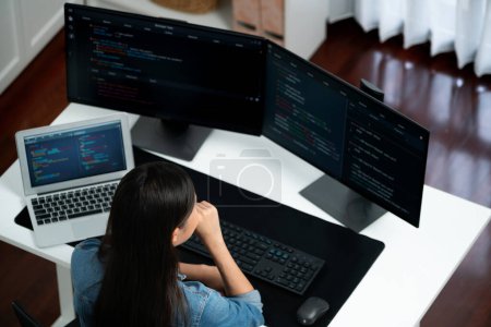 Photo for Top view young Asian IT developer creating with typing online information on pc with coding program data of website application, wearing jeans shirt. surround by safety analysis two screen. Stratagem. - Royalty Free Image