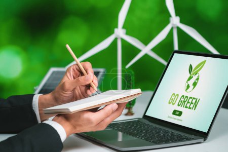 Empresario que trabaja en la oficina desarrollando un plan o proyecto sobre energía alternativa ecológica con tecnología de células solares en la pantalla del ordenador para un entorno más verde, aparte del esfuerzo de RSE. Gyre.