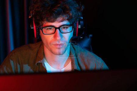 Photo for Stressful young gaming streamer team concentrated with Esport online on computer fighting harder game level with surprise face to try winner, practising strategy plan at neon lighting room. Gusher. - Royalty Free Image