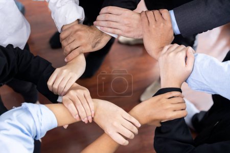 Photo for Multicultural business people holding hand together in circle. Unity teamwork in office business workplace. Diverse ethnic office worker engaged in team building. Meticulous - Royalty Free Image