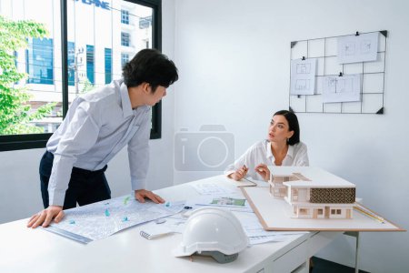 Photo for Professional architect team work together and discuss about house design with blueprint, map and architectural equipment at office. Creative business design and teamwork concept. Immaculate. - Royalty Free Image