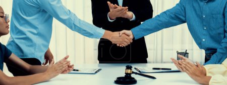 Photo for Lawyer acting as legal mediator successfully broke a compromise and seal with handshake between two parties to resolve business dispute through negotiation at law firm office. Panorama Rigid - Royalty Free Image