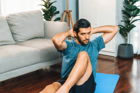 Photo for Athletic and sporty man doing crunch on fitness mat during home body workout exercise session for fit physique and healthy sport lifestyle at home. Gaiety home exercise workout training concept. - Royalty Free Image