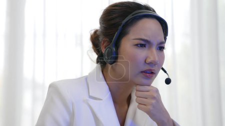 Foto de Mujer de negocios que usa auriculares que trabajan en la oficina para apoyar a un cliente remoto o colega. Agente de atención al cliente frustrado y cansado centro de llamadas que enfrenta el problema de proporcionar un servicio de vivacidad - Imagen libre de derechos