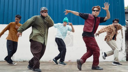 Photo for Group of hip hop choreographer dancing street dance together at wall. Young break dancer practicing break dance, moving to modern rhythm, express feeling of lively. Outdoor 2024. Endeavor. - Royalty Free Image