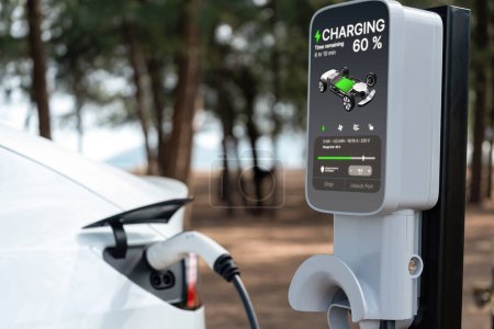 Photo for Electric car recharging battery at outdoor EV charging station for road trip or car traveling by the seascape beach, alternative and sustainable energy technology for eco-friendly car. Perpetual - Royalty Free Image