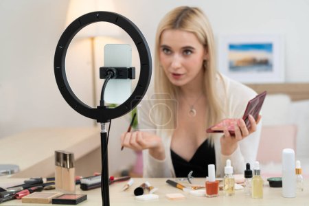 Photo for Young woman making beauty and cosmetic tutorial video content for social media. Beauty blogger smiles to camera while showing how to beauty care to audience or followers. Blithe - Royalty Free Image