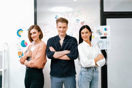 Photo for Professional successful caucasian business team crossing arm with confident while standing in front of glass board with colorful sticky notes at business meeting room. Teamwork. Immaculate. - Royalty Free Image