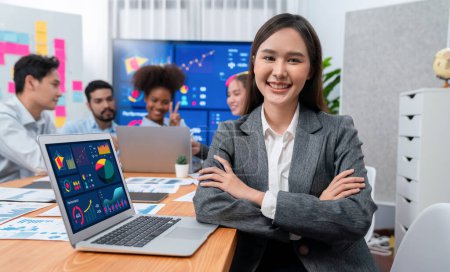 Photo for Portrait of happy young asian businesswoman with group of office worker on meeting with screen display business dashboard in background. Confident office lady at team meeting. Concord - Royalty Free Image