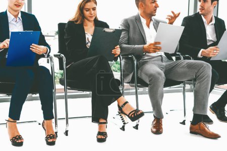 Téléchargez les photos : Les femmes d'affaires et les hommes d'affaires tenant CV dossier tout en attendant sur les chaises dans le bureau pour l'entrevue d'emploi. Concept d'entreprise et de ressources humaines. uds - en image libre de droit
