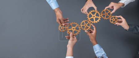 Photo for Panoramic shot top view of business people holding cog wheel as unity and teamwork in corporate workplace concept. Office worker colleague with symbol of visionary system for business success. Concord - Royalty Free Image