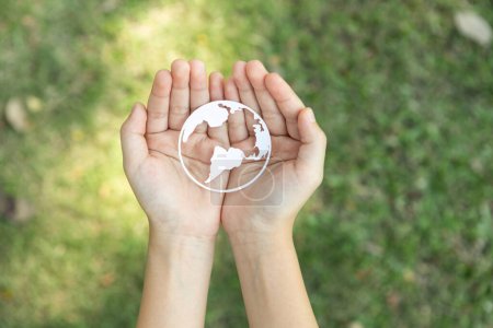 La vista superior de la mano que sostiene el icono del planeta Tierra simboliza el compromiso ecológico con la protección del medio ambiente y la emisión de carbono cero. Concepto del Día Mundial de la Tierra para promover la conciencia ecológica. Gyre.