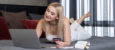 Photo for Young woman using laptop with credit card for internet banking, online shopping E commerce by online payment gateway at home office. Modern and convenience online purchase. Panorama Blithe - Royalty Free Image
