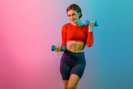 Photo for Full body length gaiety shot athletic and sporty woman with dumbbell for weight lifting as bodybuilding exercise in standing posture on isolated background. Healthy active and body care lifestyle - Royalty Free Image