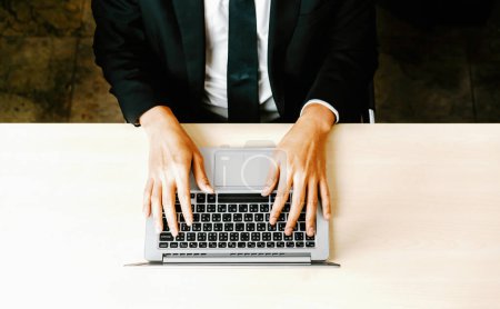 Foto de Persona de negocios u oficinista que usa computadora portátil mientras está sentado en el escritorio. BARROS - Imagen libre de derechos