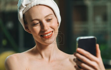 Photo for Portrait of close up beautiful caucasian woman in white towel taking video of calm and relaxing nature by using her mobile phone. Pretty girl with beautiful skin take photo. A Side view. Tranquility. - Royalty Free Image