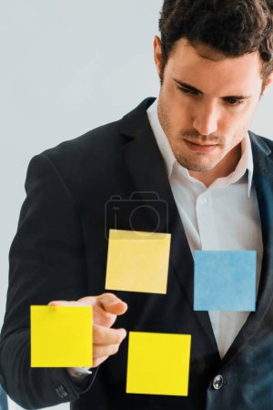 Photo for Serious businessman feels disappointed while looking at sticky note on the windows in the office. Bankruptcy and failure concept. uds - Royalty Free Image