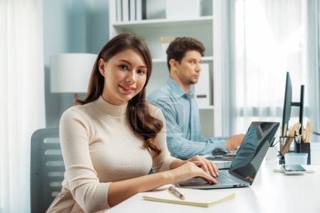 Photo for Smiling beautiful woman working on laptop aligning taking note to pose for looking at camera photo shooting portrait profiles business with smart coworker at modern office at morning time. Postulate. - Royalty Free Image