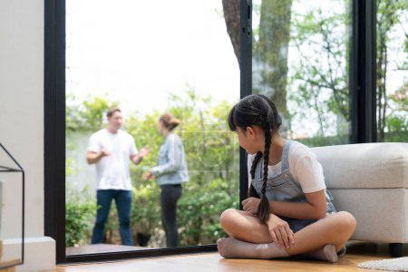 Photo for Stressed and unhappy young girl huddle in corner crying and sad while her parent arguing in background. Domestic violence at home and traumatic childhood develop to depression. Synchronos - Royalty Free Image