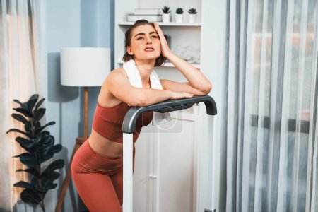 Photo for Athletic and sporty woman running on treadmill running machine during home body workout exercise session for fit physique and healthy sport lifestyle at home. Gaiety home exercise workout training. - Royalty Free Image